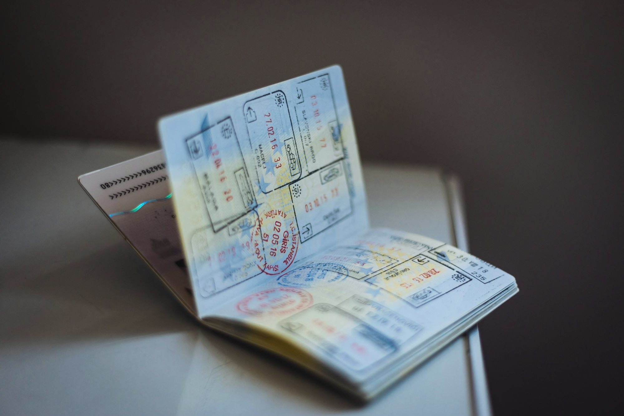 Pasaporte abierto con sellos de visado sobre un escritorio